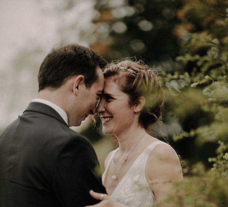 The bride and groom hugging and touching foreheads