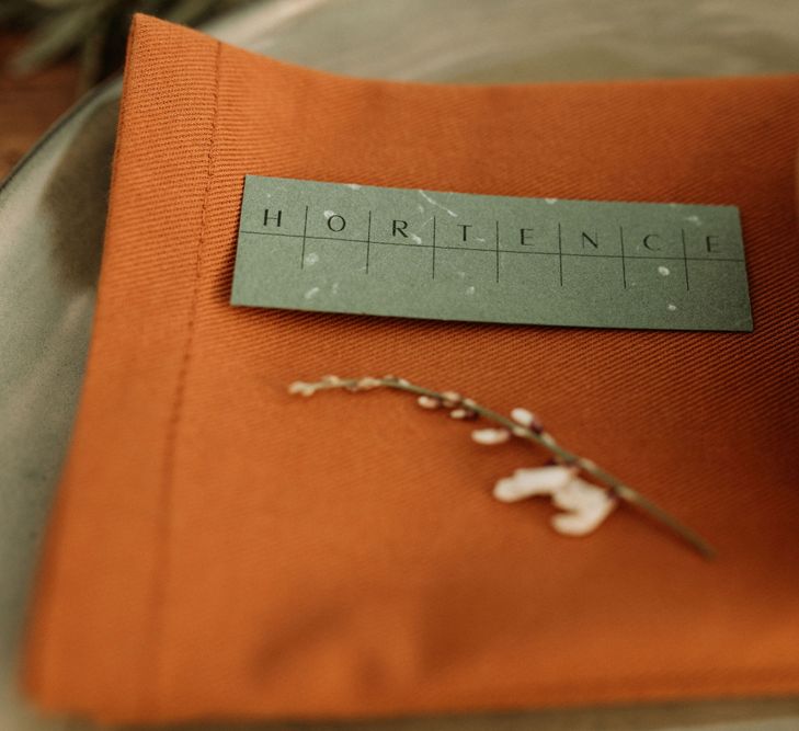 Orange napkin and green name place card 