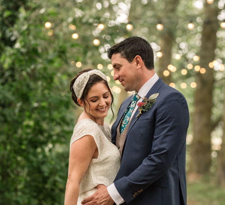 Bride & groom stand together outdoors 