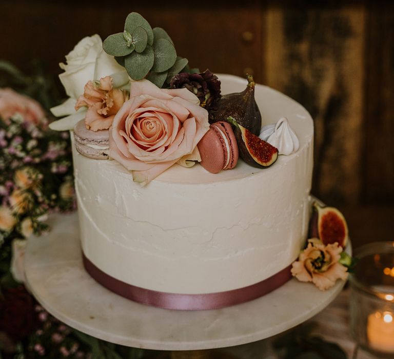 Single tier buttercream wedding cake decorated with figs, macaroons and roses 