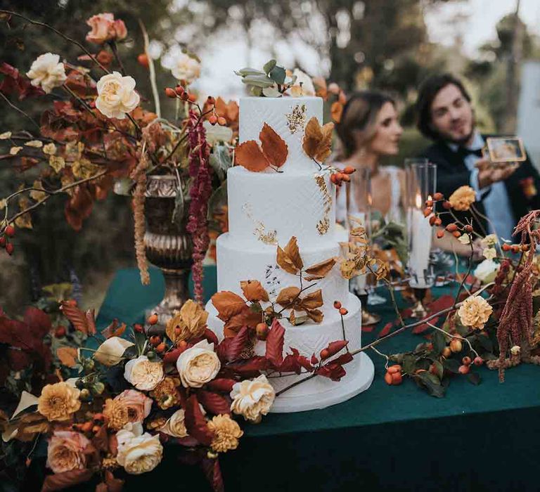 White wedding cake with Autumn colour wedding flowers