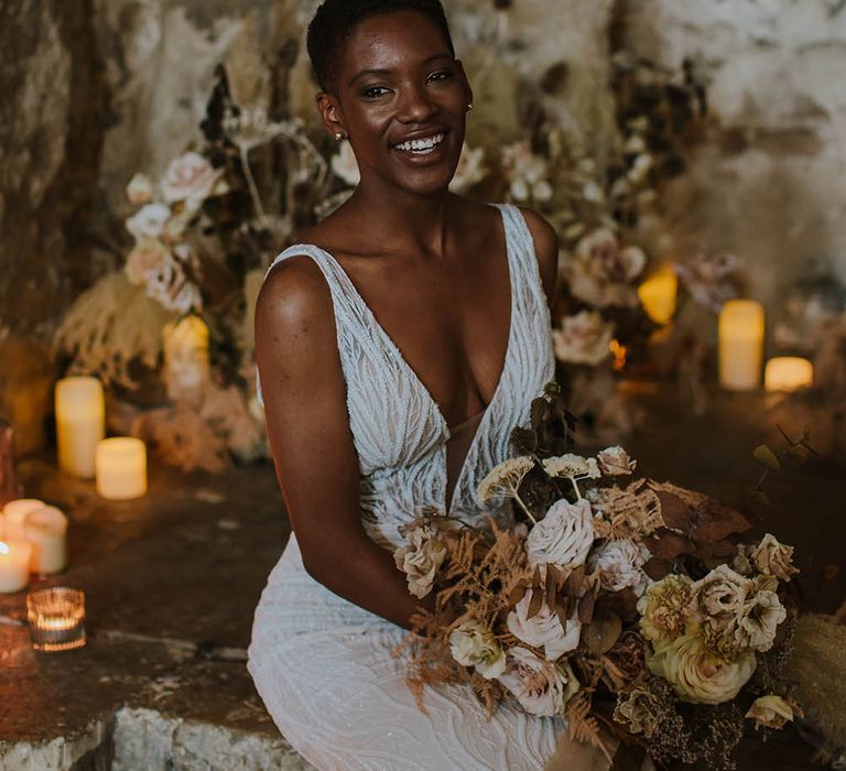 Black bride with short hair in a lace Made With Love Bridal gown holding a dried and fresh flower bouquet 