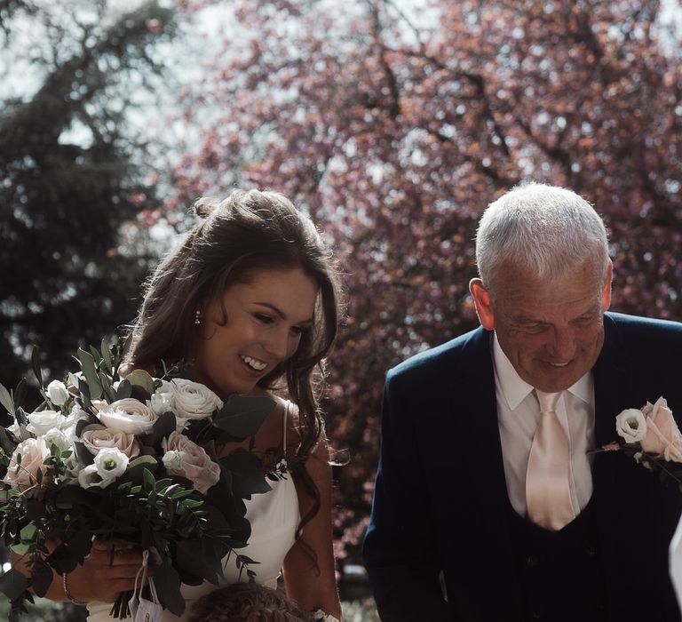 Bride being hugged by a flower girl