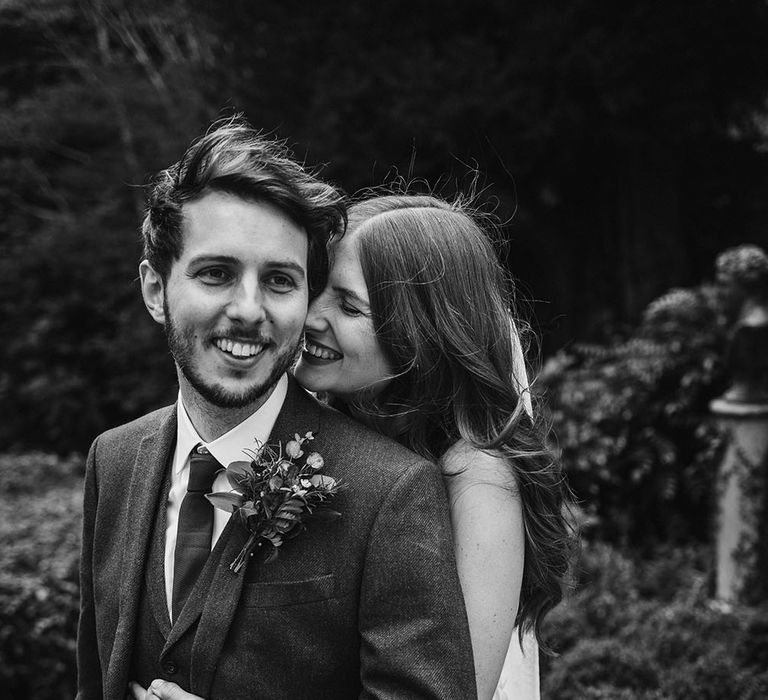 Black and white portrait of the bride embracing her husband 