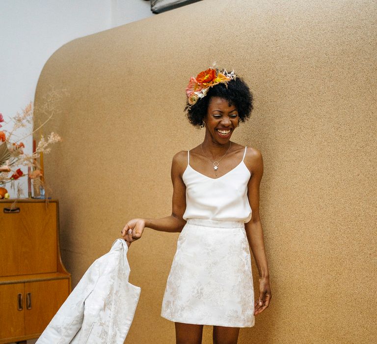 Bride wearing wedding separates of a white mini skirt with matching blazer, and a spaghetti strap bridal top