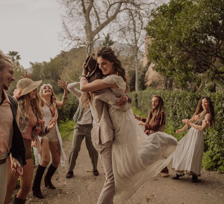 Groom picks up bride on their wedding day as they move through the countryside of Sicily 