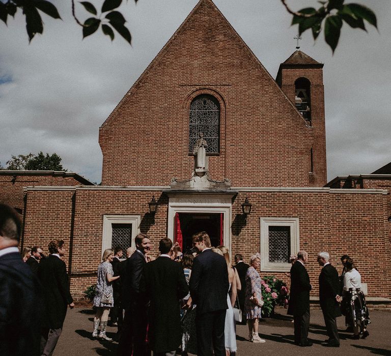 Exterior of church in Surrey as guests wait for wedding ceremony