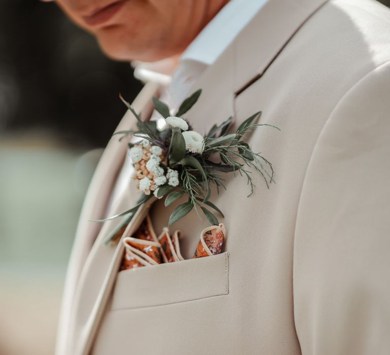 Groomsman in linen suit with red floral pocket square and white and green floral buttonhole for Wasing Park wedding