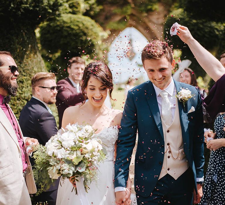 Bride & groom walk through confetti on their wedding day