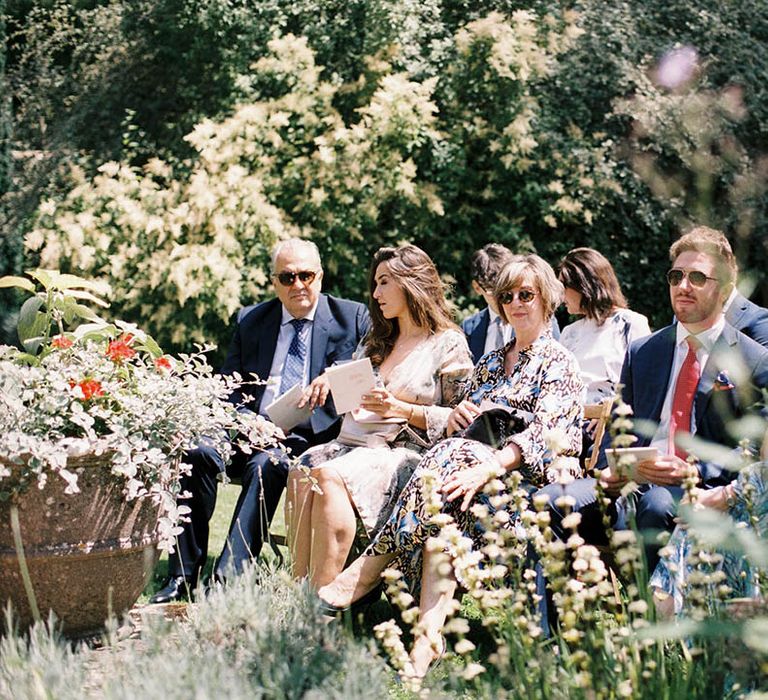 Wedding guest seated at outdoor wedding ceremony 