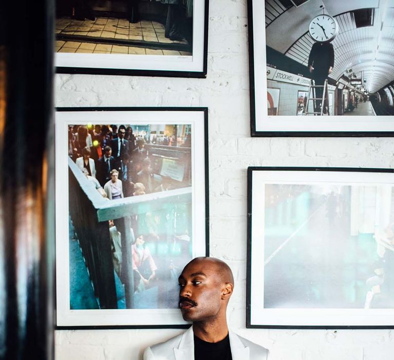 Black groom in a white suit and black t-shirt with chain buttonhole detail