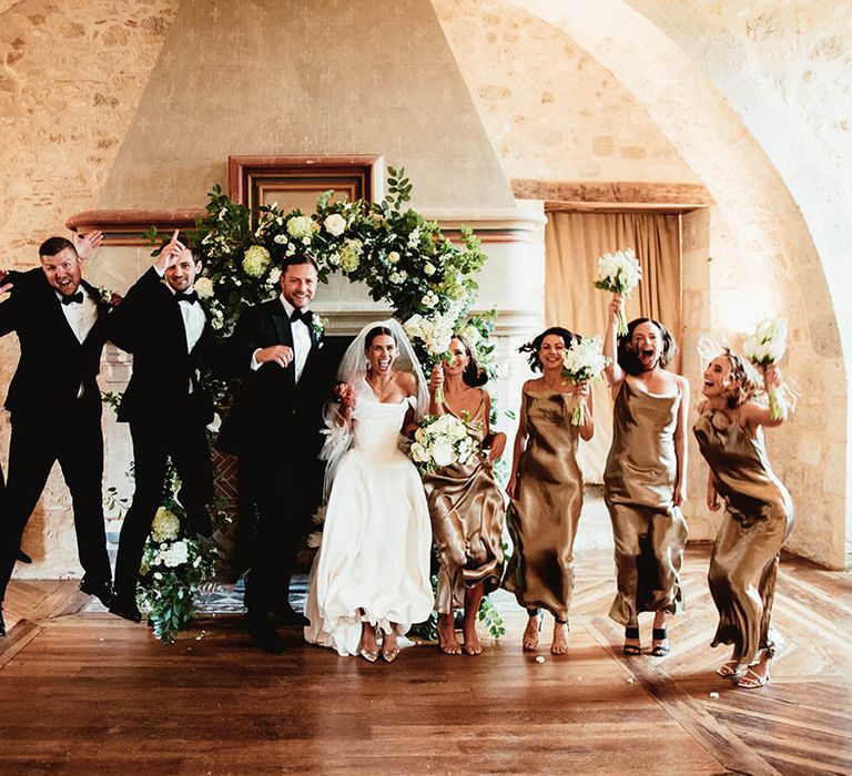 Bride & groom stand with their wedding party on wedding day