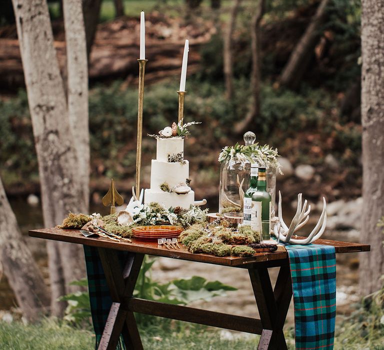 Wedding cake table and whisky station with buttercream wedding cake, moss and antler decor 