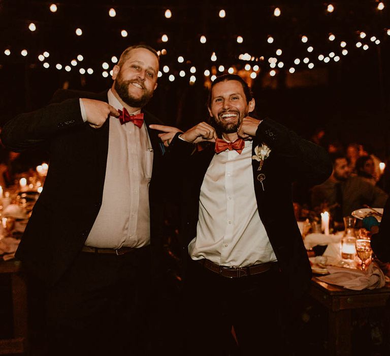 Groom smiles and laughs with wedding guest 