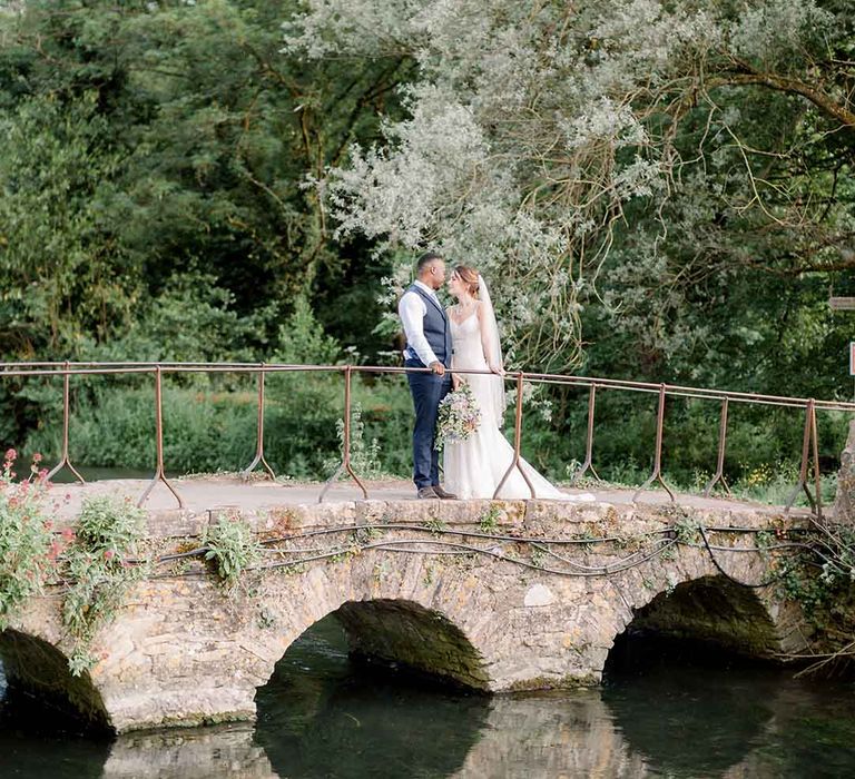 Bride & groom walk across bridge on their wedding day