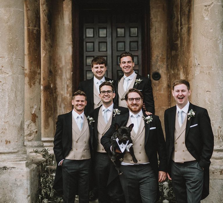 Groomsmen in matching three piece suits with cream waistcoats