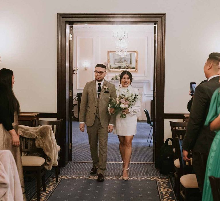 Bride and groom walking through Leatherhead Registry Office, Wotton House