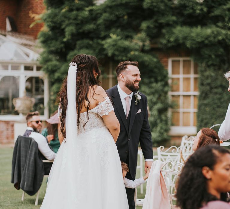 Bride and groom laugh together after their outdoor wedding ceremony