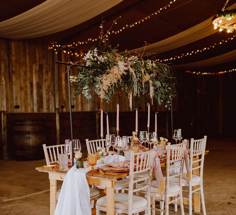 intimate table scape at Montague Farm Hankham with flower installation, pink taper candles and fabric table runner 