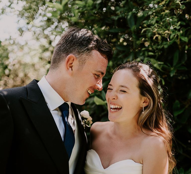 Bride & groom stand outdoors for classic fairytale wedding at Cowdray House 