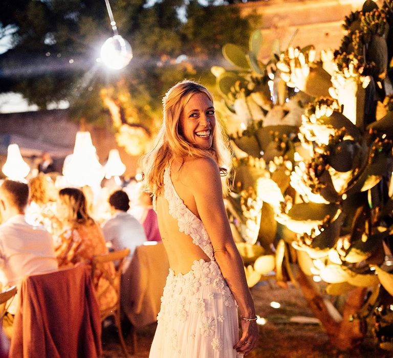 Bride with her blonde hair in a half up half down style in an Emma Beaumont flower halter neck wedding dress