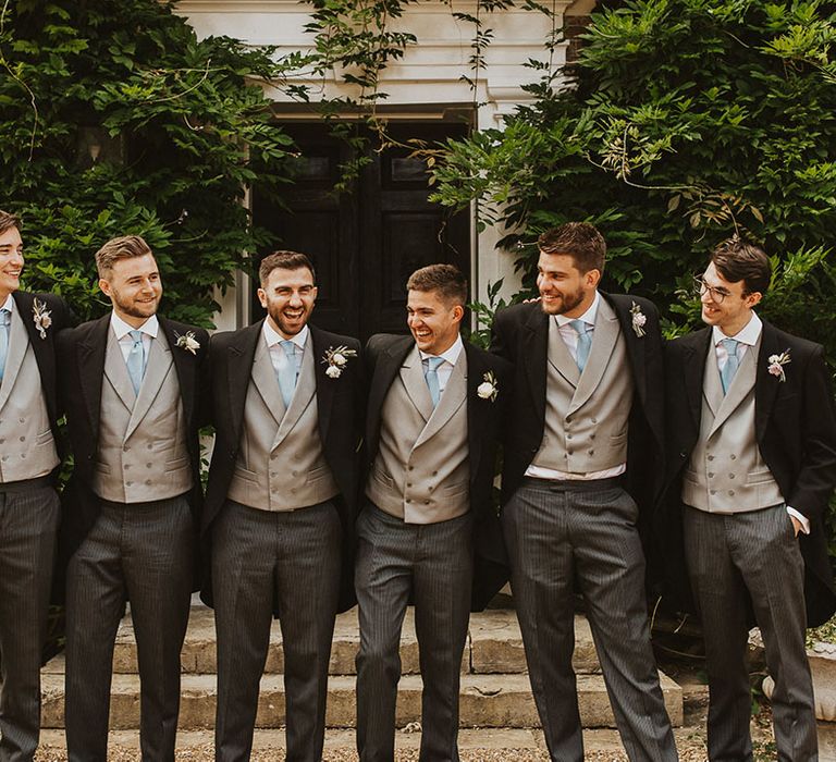 Groom with groomsmen in morning suits, light grey waistcoats and pale blue ties for the classic English wedding 