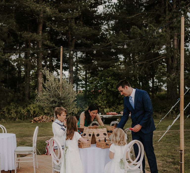 Children at the wedding dig into wicker baskets of food 