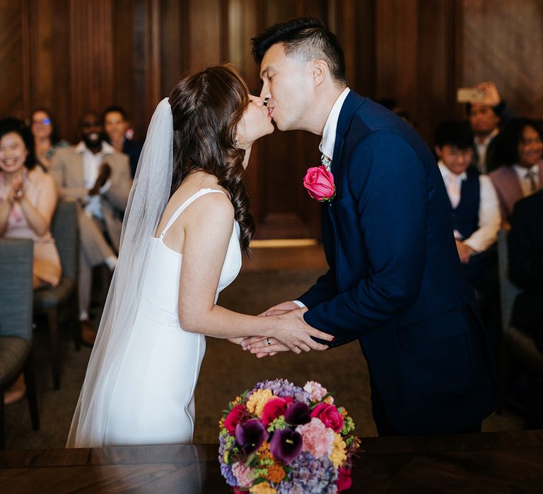 Bride & groom kiss at the Old Marylebone Town Hall during wedding ceremony 