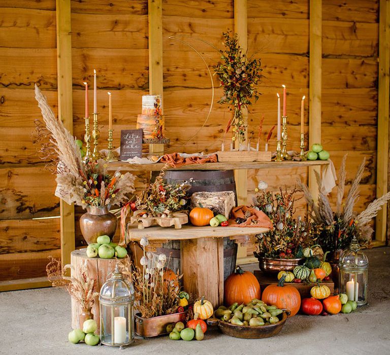 Autumn's orange & brown tones with textures of wood, naturally dyed cheesecloths & sustainable dried flowers. Hand made wood calligraphy signage and sustainable props, autumn harvest of gourds, pumpkins and last fruits from the trees, and pillar candles in large glass candle holders