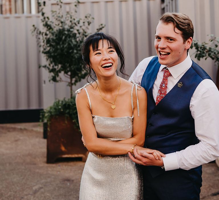 Groom holds his bride at Trinity Buoy Wharf for multicultural Chinese wedding 