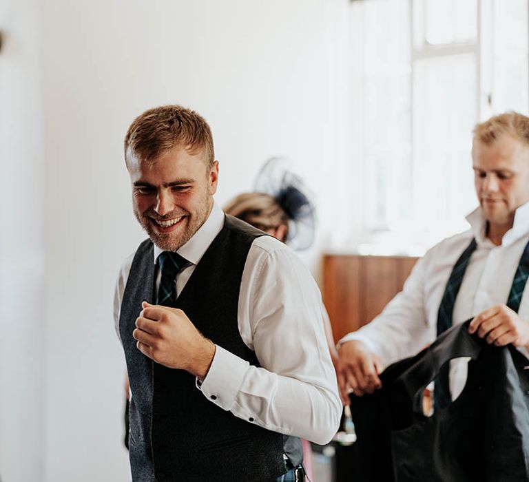 Groom in a tartan kilt and waistcoat on the morning of the wedding 