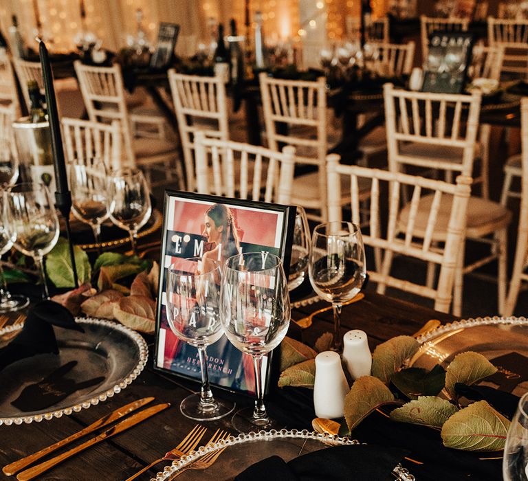 Beaded clear charger plates with black napkins, gold cutlery and black unique rock on hand sign wedding place names 