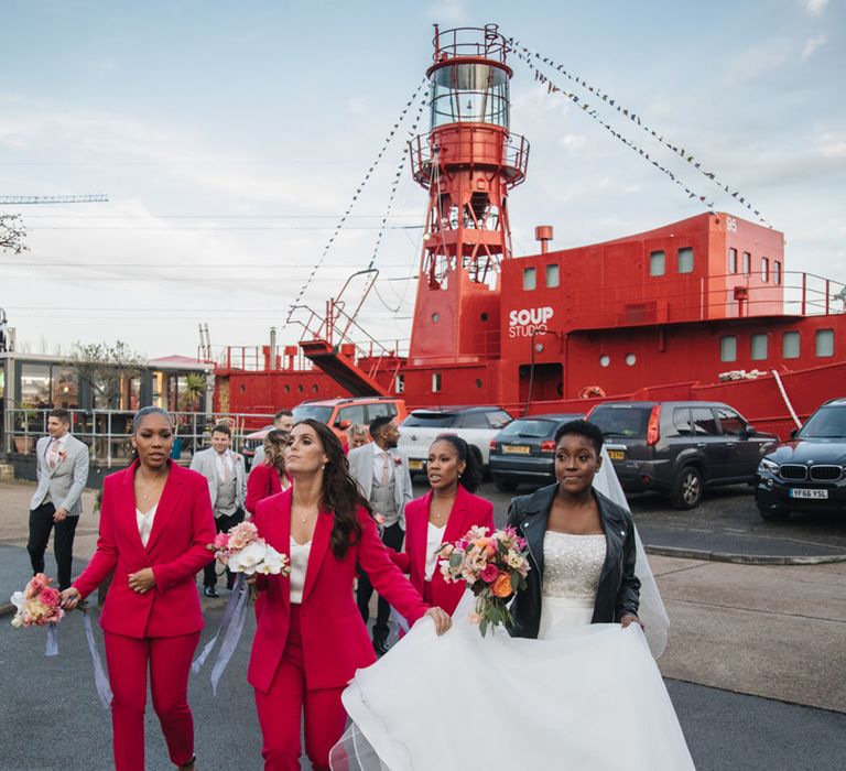 Industrial city wedding with the bridesmaids in vibrant suits and the bride in a princess wedding dress with leather jacket 