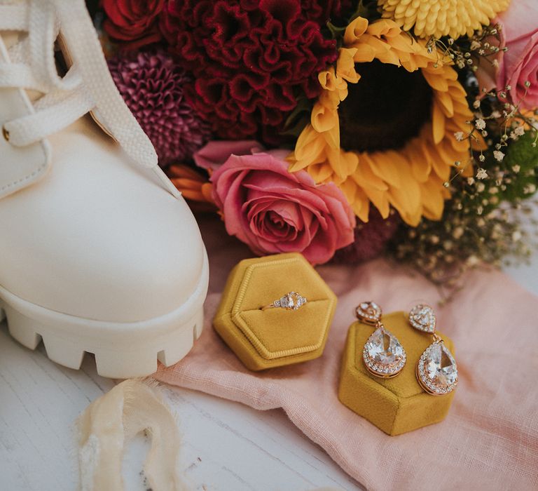 bridal accessories with earrings and wedding ring in a yellow velvet jewellery box