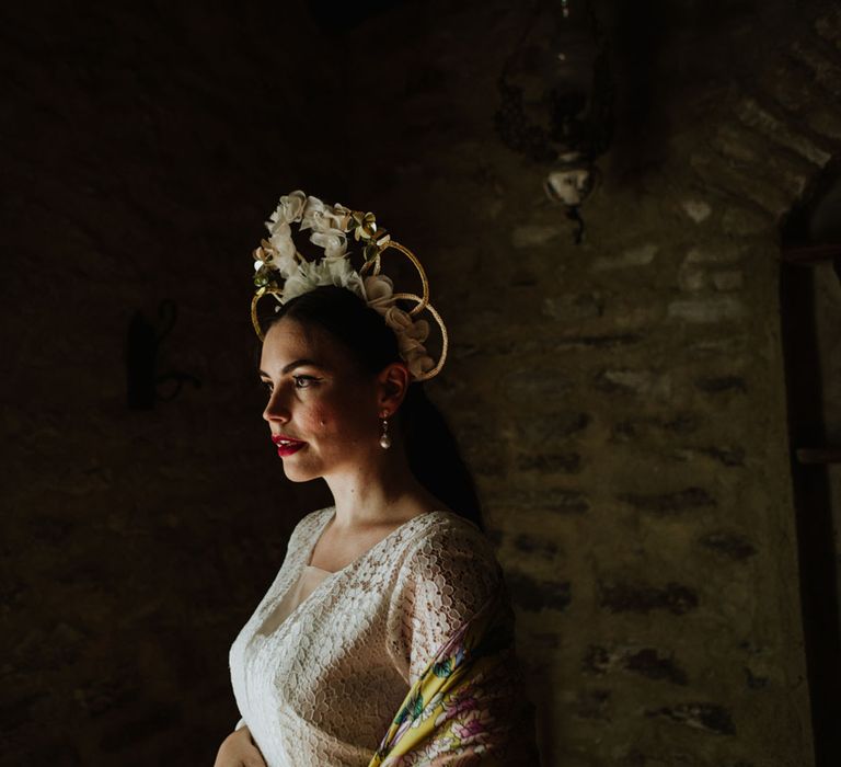 Bride inn white floral bridal crown and bohemian lace dress with a colourful pashmina, pearl earrings and red lip makeup look