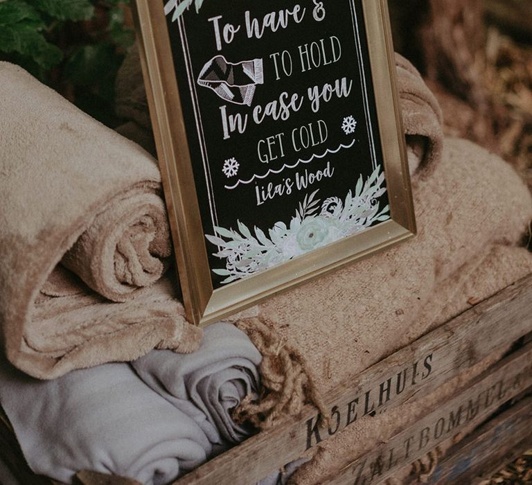 Chalkboard sign instructing guests to take a blanket wedding favour for outdoor woodland wedding 