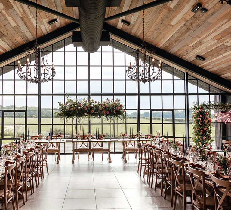 The Barn at Botley Hill wedding venue with colourful flower arrangements, neon signage and table decor with a blue and orange colour scheme