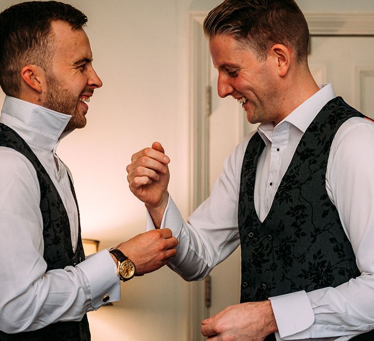 The groom and groomsmen help each other get ready on the morning of the wedding 