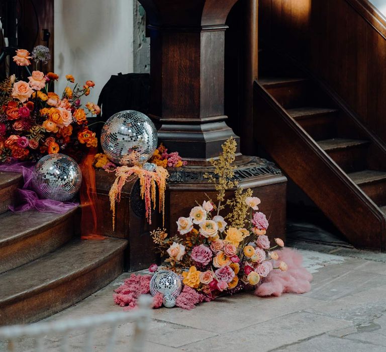 Fabrica Brighton wedding venue reception room with colourful flower arrangements and disco ball wedding decor 