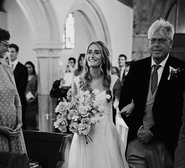 church wedding ceremony with the father-of-the-bride walking his daughter down the aisle in a Suzanne Neville princess wedding dress