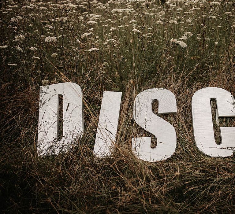 Giant disco wedding sign on grass on classic Hollywood sign style 