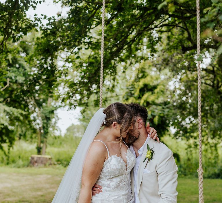 Houchins barn wedding venue with the bride wearing a floral lace wedding dress and groom in a beige suit jacket