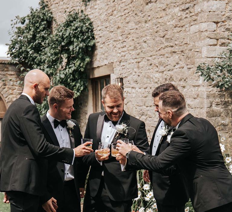 Groosmen in tuxedos drinking whiskey