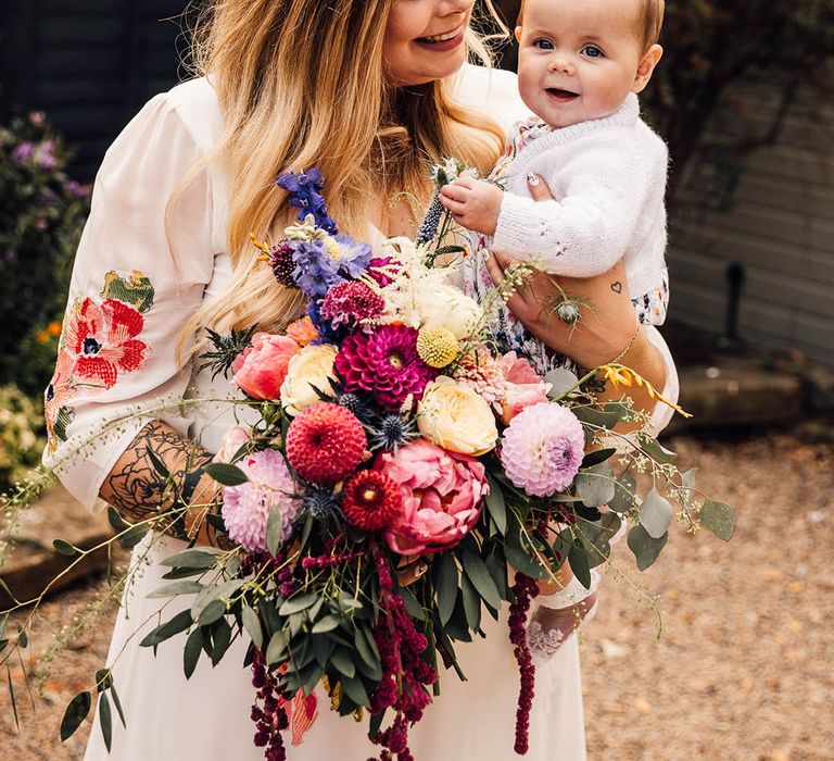 Bride with little baby holding wedding bouquet at botanical boho wedding day at The Parlour, Blagdon