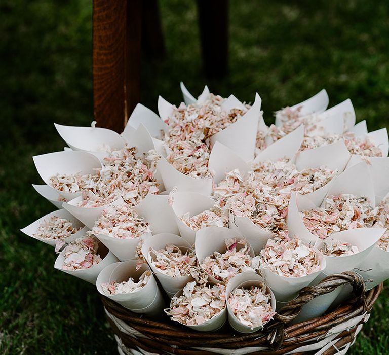 Confetti cones filled with dried petals in wicker basket 