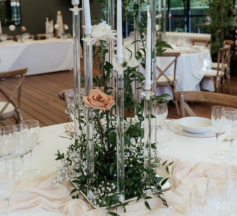 Wedding table centrepieces with neutral wedding flowers, clear acrylic candelabras and wedding drapery 