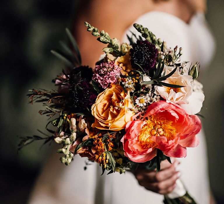 Bride holding colourful wedding bouquet for city wedding 