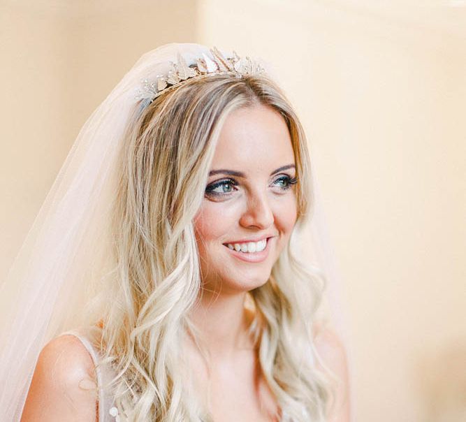 Bride with long wavy hair, wedding veil and crown