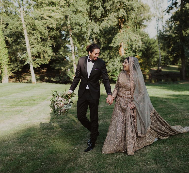 Portrait of the groom in tuxedo and the bride in a gold dress 