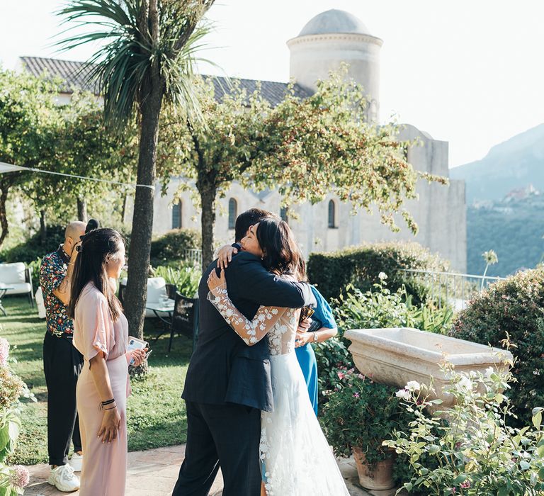 Bride embracing her wedding guests in a bridal jumpsuit